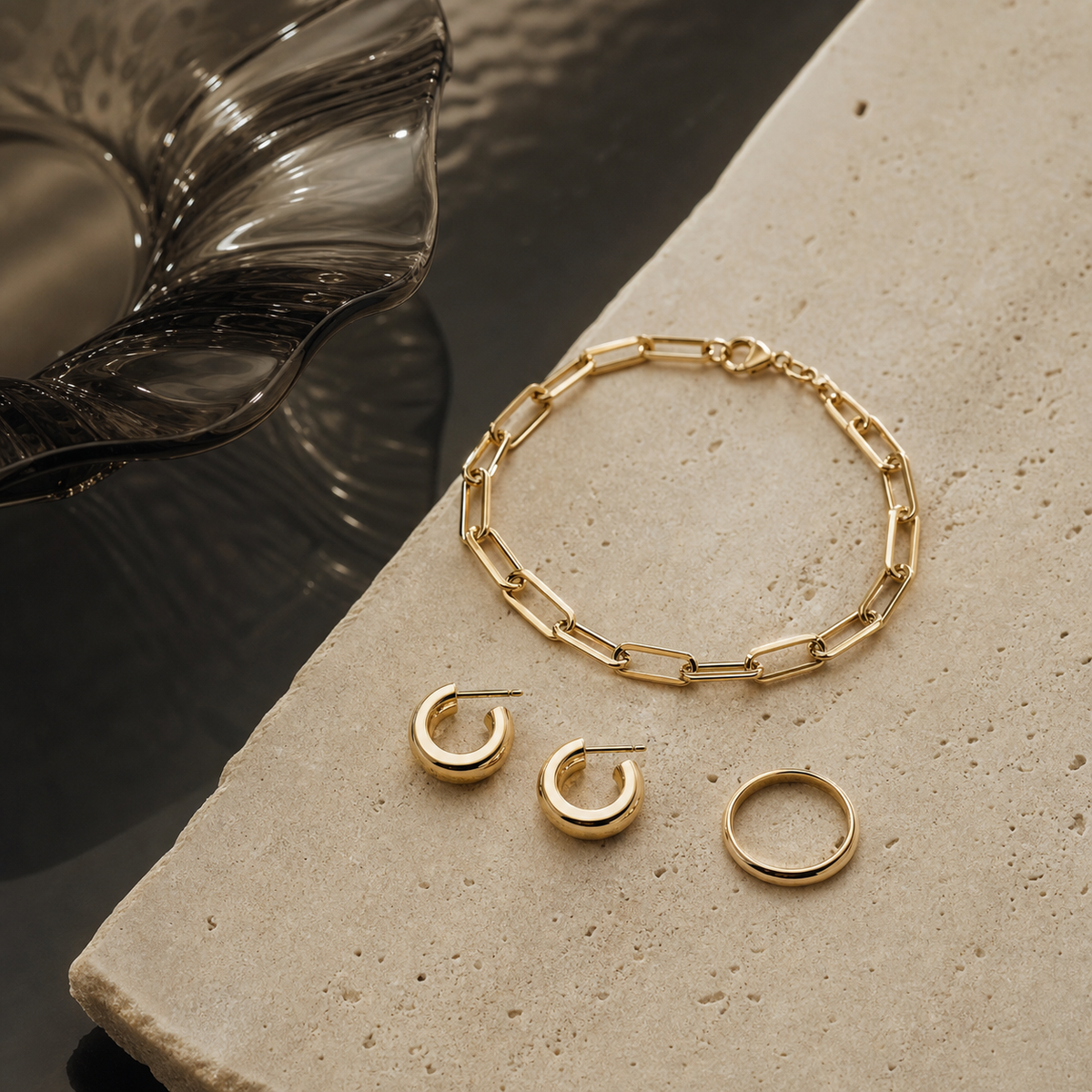 Generic gold jewelry arranged on cream stone